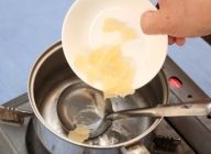 鍋のシロップが冷めたら、ゼラチンを手でちぎりながら入れて混ぜ溶かす。　ゼラチン入りのシロップを更に冷ます。