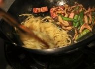 火をつけ、スパゲティの上に昆布茶と白コショウを加え、麺と汁を混ぜ合わせ、味を含ませる。先に麺を皿に盛り付け、具材を上に盛れば完成。