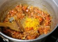 トマトが煮崩れて水分が出たところにパウダースパイス、塩を入れ、水50mlを入れてかき混ぜる。そこへチャナ豆（ひよこ豆）を加える。