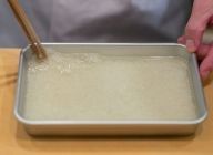 【生地】水と砂糖を煮溶かし、バットに入れた道明寺粉に注ぎ込む。即座にお箸で道明寺粉がバラバラになるまでよく混ぜる。