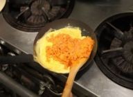 フライパンにバターを入れ、卵を入れ、フライパンで卵を混ぜ、広げる。卵の真ん中に、炒めたご飯をのせる。フライパンの柄をトントンたたきながら、卵を回してご飯にかぶせ