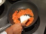 ハムが炒められたらケチャップを回し入れ、混ぜ炒め、ケチャップが材料によく混ざったら、ご飯を加えてさらに混ぜ炒める。
