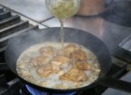 そこへ鶏もも肉と肉汁を戻し、ビールを注ぎ、中～強火でひと煮立ちさせる。沸いたら、味の引き締め役のディジョンマスタードを加えて混ぜる。