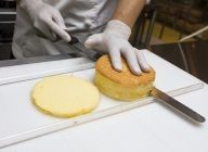 焼き上がったら型からはずし、紙はつけたままで冷ます。冷めたら1cmの厚さに2枚スライスする。※残りもスライスし、冷凍しておくと他のケーキに使用できる。