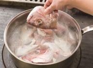 鍋にお湯を沸かし、お湯に対し約１％程の酢を加えたところに、よく洗った鯛のガラを入れ、短時間（1分ほど）加熱（ブランシール）する。