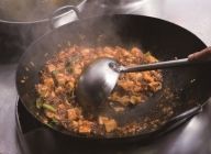 お玉の丸い部分で豆腐を押すように、鍋を揺らしながら混ぜる。焦がさないこと。