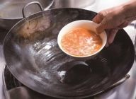 卵液に炒めたトマトを一気に加え、卵の周囲が熱で少し固まりかけるまでひと呼吸おく。鍋に脂を十分熱したところに卵液を入れる。