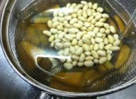 同時に水煮の大豆も水から入れて沸騰したら水で冷やします。ざるを使って仕切れば混ざらずに同時に冷やせます。
