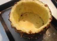 パイナップル上下の皮を底にして器を二個作り、クリームを流し込み、オーブンか、魚焼きグリルで焼き色がつくまで焼く。大葉（分量外）とアイスを添えて盛り付ける。