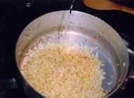 STEP2の鍋に米を入れ、米が半透明になるまで炒め、白ワインを注ぐ。