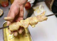 焼く直前に、鶏むね肉をきれいに揃うように鉄串に刺していく。