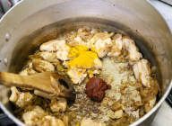 さらに鶏肉を入れ、表面が白くなるまで炒める。トマトペーストとターメリックパウダーを加えて混ぜ、全体にからめる。