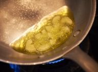 フライパンにEXVオリーブオイル(50ml)とにんにくを入れて中火にかける。フライパンを斜めにし、オイルでにんにくを揚げるようにすると良い。
