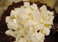チョコレートとバターをボウルに入れます。\n湯煎をして、混ぜ合わせながら溶かします。