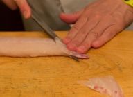 鯛のしっぽのほうからやや厚めに、斜めに切りつける。