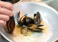 鍋にニンニク・黒胡椒・誘い水・オリーブオイルを入れ、ムール貝を並べて火にかける。