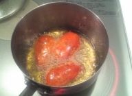 赤パプリカと黄パプリカを180~190度のサラダオイルで両面揚げ、１～２分揚げ火を通す。飾り用のバジルも素揚げする。油がはねるので気をつける。