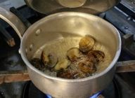 【パエリャ】アサリと白ワインを鍋に入れ中火にかけ、フタをする。貝が開いたらバットなどに汁ごと移しておく。※砂が入っていれば濾しておく。