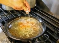 ニンニクの香りがでたら、魚のブイヨン200～250cc、炒めた玉ねぎ大さじ1、トマトピューレ、サフランを加え軽く沸騰させ、塩で薄く味をつけて2～3分火にかける。