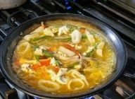 米をパエリア鍋に入れ、パプリカ、インゲン、イカ、ほぐした鯛の身をのせる。