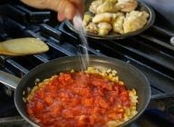 そこへダイストマトを加え、塩で軽く味をつけ、10分程煮込む。