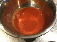 トマトソース作り。バターでニンニクを炒めてトマト缶を加えて10分煮て、ミキサーにかけて濾しておく。