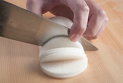 包丁を入れたら、野菜を持つ人差し指を、切り取る側の大根の角にのせて固定し、切り落とす。そして次へ、を繰り返す。