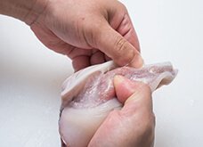 【エンペラ】皮の端をとっかかりに皮をつまみ、むく。タオルやキッチンペーパーを使うと滑らず、むきやすい。